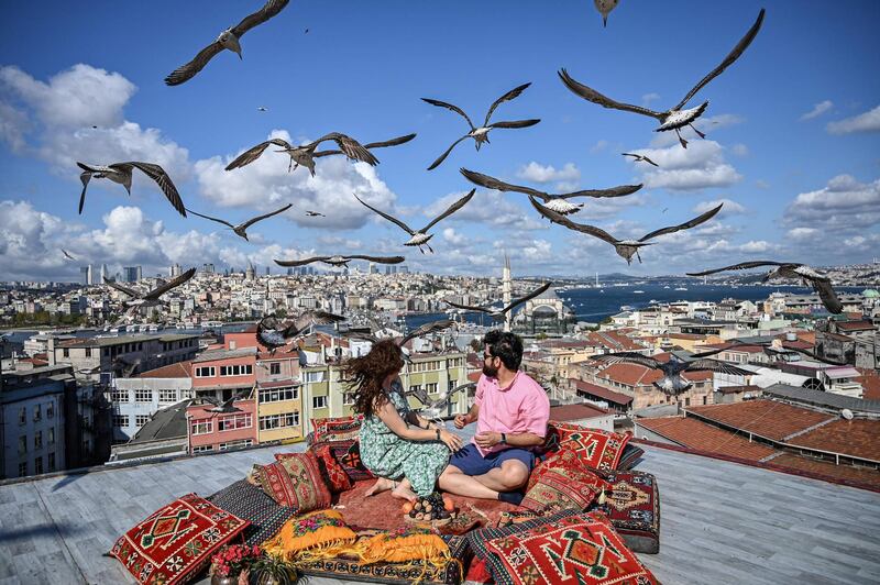 A couple sit on the terrace of a cafe in Istanbul, Turkey, as seagulls fly over them. AFP