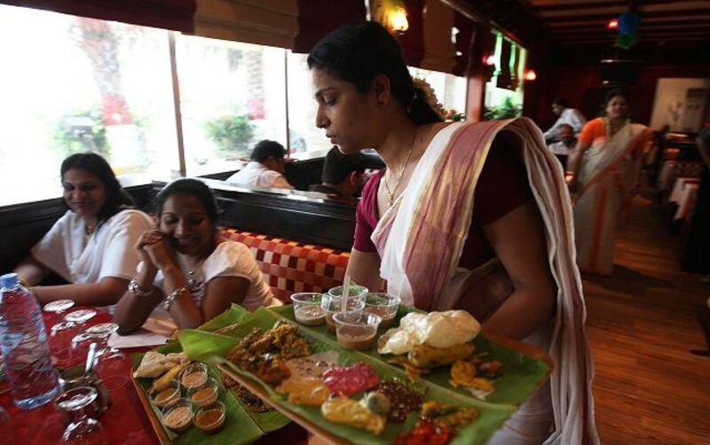 Ani Jacob serves a traditional meal set on banana leaves as part of the New Year menu at Nalukettu restaurant in the Dubai Grand Hotel.