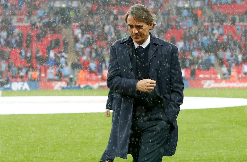 Manchester City's manager Roberto Mancini reacts in the rain after his team was defeated by Wigan Athletic in their FA Cup final soccer match at Wembley Stadium in London May 11, 2013.            REUTERS/Darren Staples (BRITAIN  - Tags: SPORT SOCCER)   *** Local Caption ***  LON059_SOCCER-ENGLA_0511_11.JPG