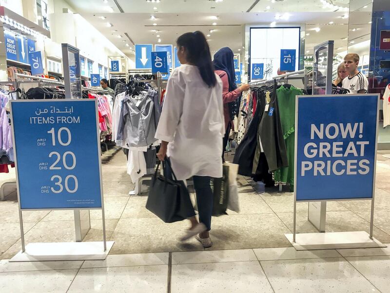 DUBAI, UNITED ARAB EMIRATES. 21 DECEMBER 2017. Shopping in Dubai Mall before the implementation of VAT across the UAE. A shopper enters a store in Dubai Mall displaying SALE signs. (Photo: Antonie Robertson/The National) Journalist: None. Section: National.