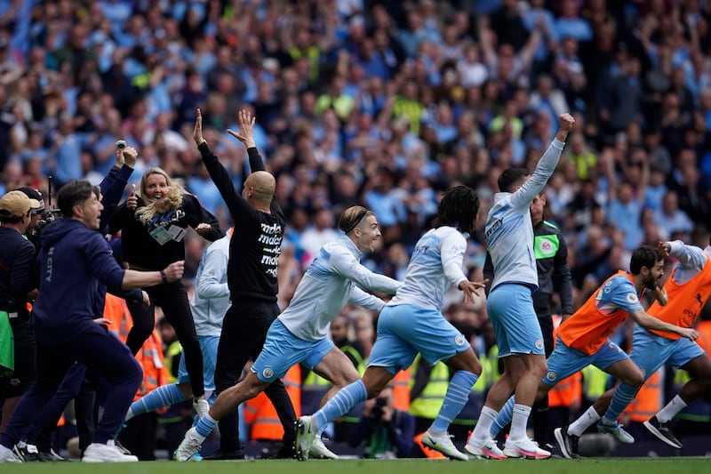Manchester City coach Pep Guardiola and his team celebrate after winning the Premier League. AP