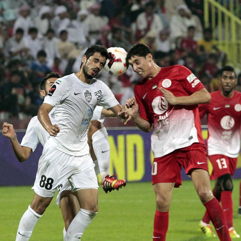 Al Ahli's Majed Hassan, left, battles Abdelaziz Barrada of Al Jazira for a header during Thursday night's action in Dubai. Jeffrey E Biteng / The National 