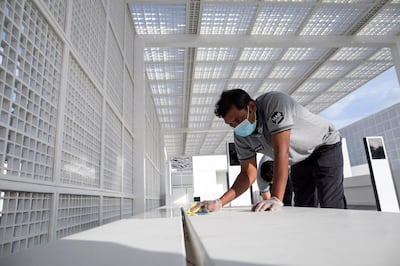 epa08295070 A worker cleans outside the Louvre Abu Dhabi museum after it was announced it would be closed amid the ongoing coronavirus pandemic, in Abu Dhabi, United Arab Emirates, 15 March 2020. The United Arab Emirates shut down major tourism and cultural venues, including some parks, until 30 March 2020.  EPA/MAHMOUD KHALED