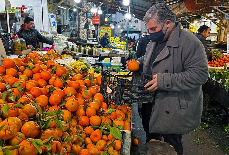 Jordanian chef Omar Sartawi buying oranges at a market in Amman.