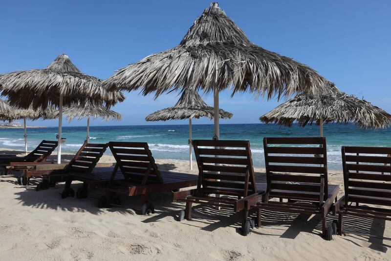 (FILES) In this file photo taken on May 4, 2020, empty sunbeds lie along a beach in the Cypriot resort town of Ayia Napa, as the island country gradually eases lockdown restrictions placed for the COVID-19 coronavirus pandemic. Cyprus hopes to attract tourists after its coronavirus lockdown by paying the medical costs of anyone who tests positive for COVID-19 while holidaying on the island, officials said on May 27. The plan was outlined in a letter to tour operators and airlines detailing the health and safety protocols Cyprus is implementing to ensure the safety of its tourism sector. / AFP / Christina ASSI
