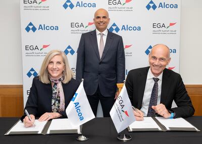 Simon Storesund, chief supply chain and business development officer of EGA, and Kelly Thomas, executive vice president and chief commercial officer of Alcoa, sign the agreement in the presence of EGA chief executive Abdulnasser bin Kalban. Photo: EGA