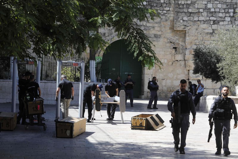 Israeli border policemen install metal detectors outside the Lion's Gate, a main entrance to Al-Aqsa mosque compound, in Jerusalem's Old City, on July 16, 2017, after security forces reopened the ultra-sensitive site, whose closure after a deadly attack earlier in the week sparked anger from Muslims and Jordan, the holy site's custodian. 
Three Arab Israeli assailants opened fire on Israeli police on July 14 in the Old City, killing two of them before fleeing to the nearby Haram al-Sharif compound, where they were shot dead by police. / AFP PHOTO / Menahem KAHANA