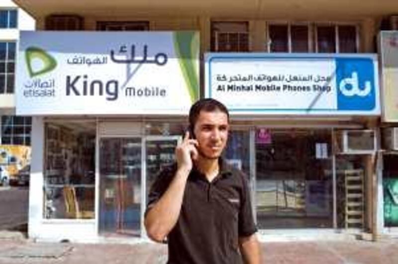 Abu Dhabi - July 28, 2008: Nezir Al Smadi, 26, talks on his cell phone in front of mobile phone shops on 11th street. ( Philip Cheung / The National ) *** Local Caption ***  PC0010-etisalatdu.jpgPC0010-etisalatdu.jpg