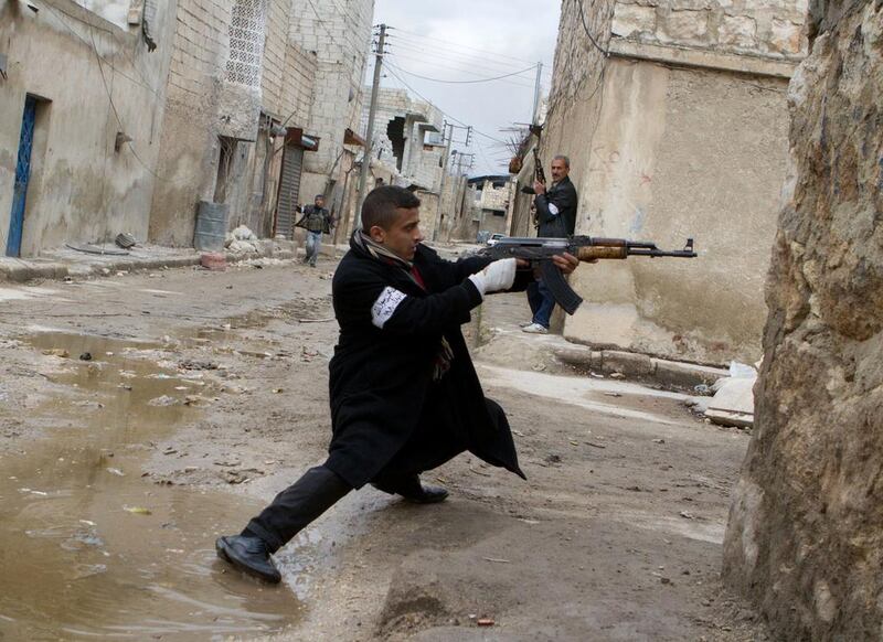 A Syrian rebel aims his weapon during clashes with government forces in Aleppo. Stephen Boitano / AFP

