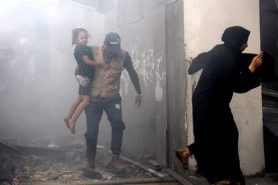 Members of a Palestinian family rush out of a bombed house during Israeli airstrikes on Gaza City on October 9. AFP