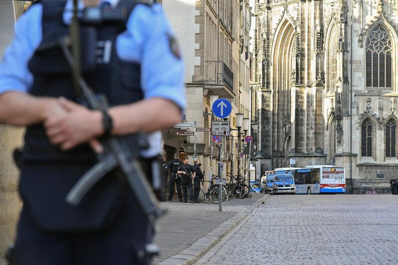 An armed policeman stands guard at the attack site in Munster. Sascha Steinbach / EPA