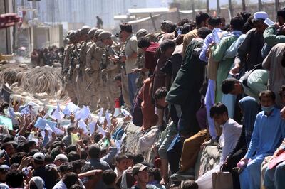 Afghans struggle to reach the foreign forces to show their credentials to flee the country outside the Hamid Karzai International Airport, in Kabul. EPA