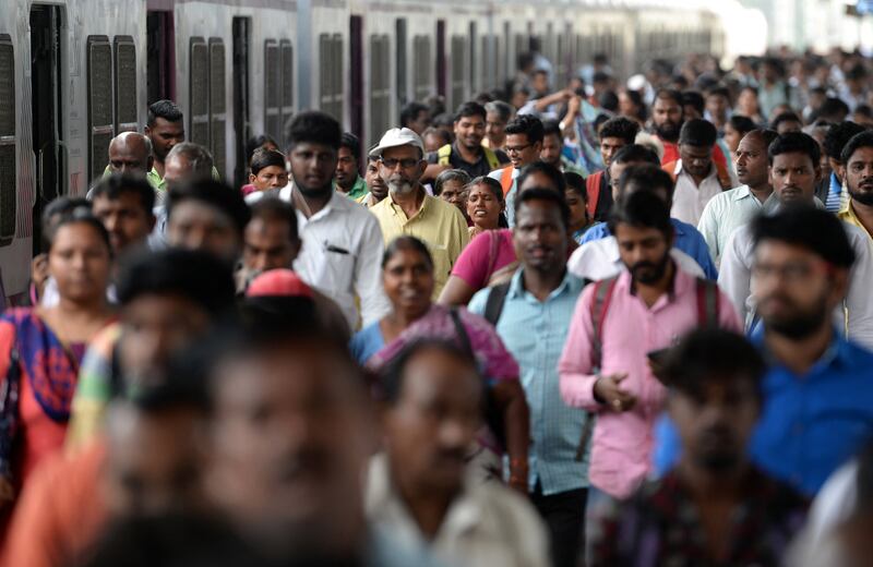 Indian commuters make their way through a central railway station at rush hour in Chennai.