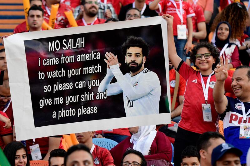 A fan holds up a message for Egypt's Mohamed Salah ahead of the 2019 Africa Cup of Nations match between Uganda and Zimbabwe at the Cairo International Stadium on June 26 , 2019. AFP