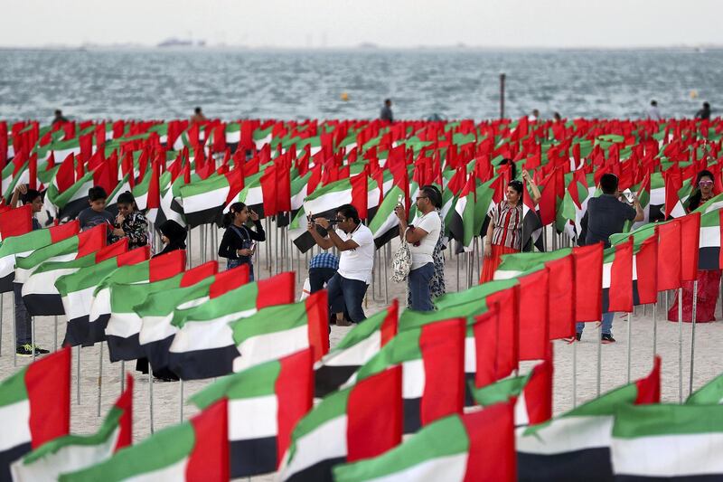 DUBAI , UNITED ARAB EMIRATES , NOV 30  – 2017 :- People taking their photos with the UAE flags on the national holiday with their family and friends at the Kite Beach in Dubai. (Pawan Singh / The National) Standalone