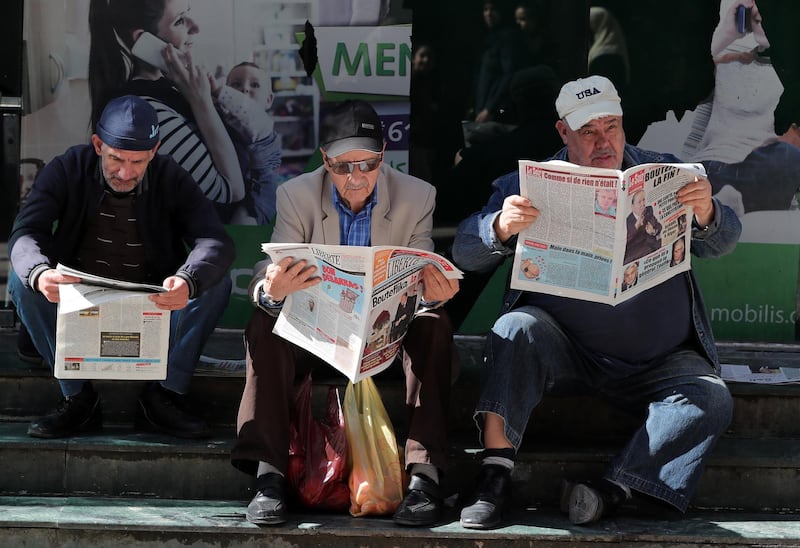 Algerian men read local newspapers a day after Algeria's President Abdelaziz Bouteflika submitted his resignation, in Algiers. EPA