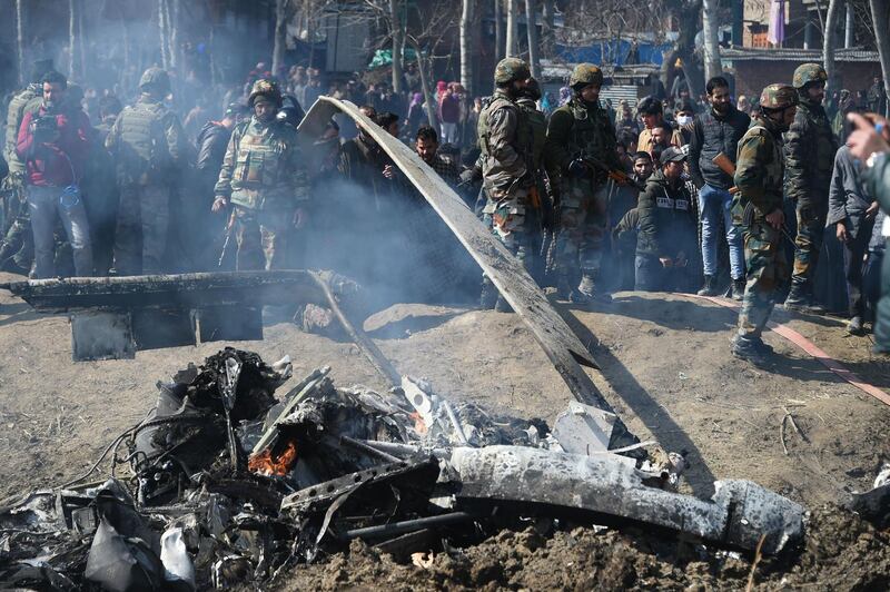 Indian soldiers and Kashmiri onlookers stand near the remains of an Indian Air Force aircraft after it crashed in Budgam district, some 30 kms from Srinagar.  AFP