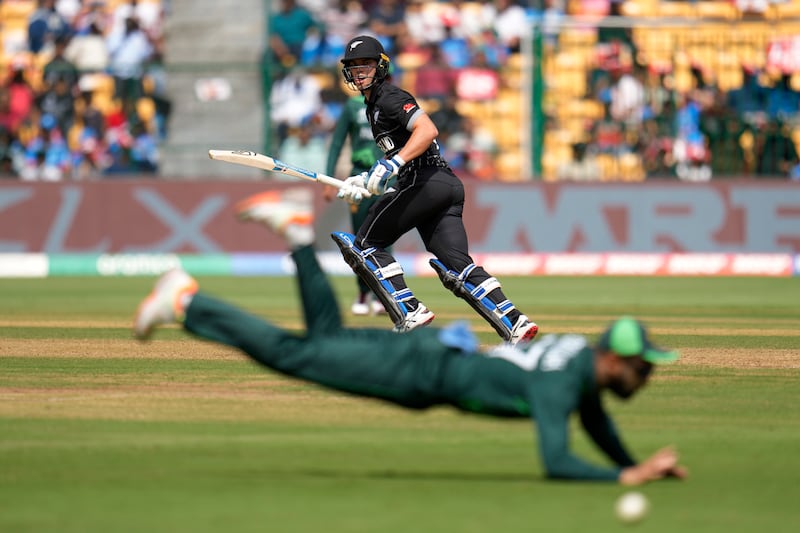 Pakistan Abdullah Shafique attempts to stop the ball as New Zealand batter Mark Chapman sets off for a run. AP
