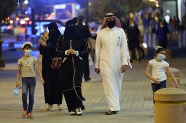 A Saudi family wearing protective face masks walk on Tahlia Street in Riyadh as nightlife kicks off after the government loosened coronavirus restrictions. Reuters