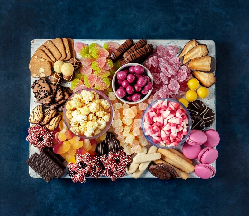From macarons and candy to caramelised nuts, popcorn and fruit, make yours a dessert board to remember. Getty Images