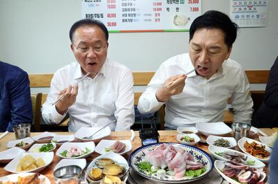 Kim Gi-hyeon (R), chief of the ruling People Power Party, and the party's floor leader, Yun Jae-ok, eat slices of raw 'mineo,' or croaker fish, for lunch at a raw fish restaurant in Incheon, west of Seoul, South Korea, on August 29, to promote sales of fish amid Japan's release of radioactive water into the ocean.  EPA 