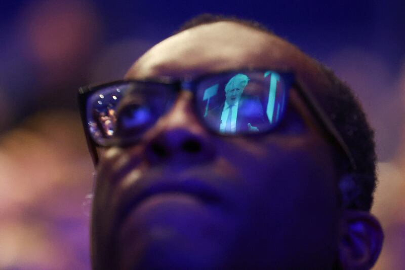 Former British prime minister Boris Johnson is reflected in Mr Kwarteng's glasses. Reuters