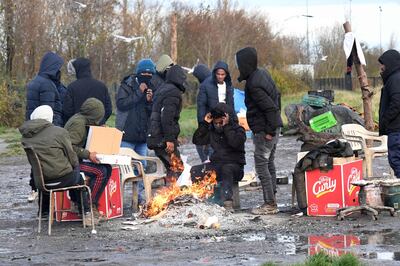 Huddling around a fire at a migrants' camp in Calais, northern France. AFP