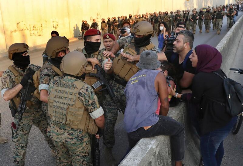 Anti-government protesters try to release their friend from the Lebanese soldiers, during a protest against the Lebanese President Michel Aoun near the presidential palace, in Baabda east of Beirut. AP Photo