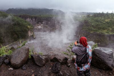 A resident takes photos after lava flowed from Indonesia's most active volcano Mount Merapi. AFP