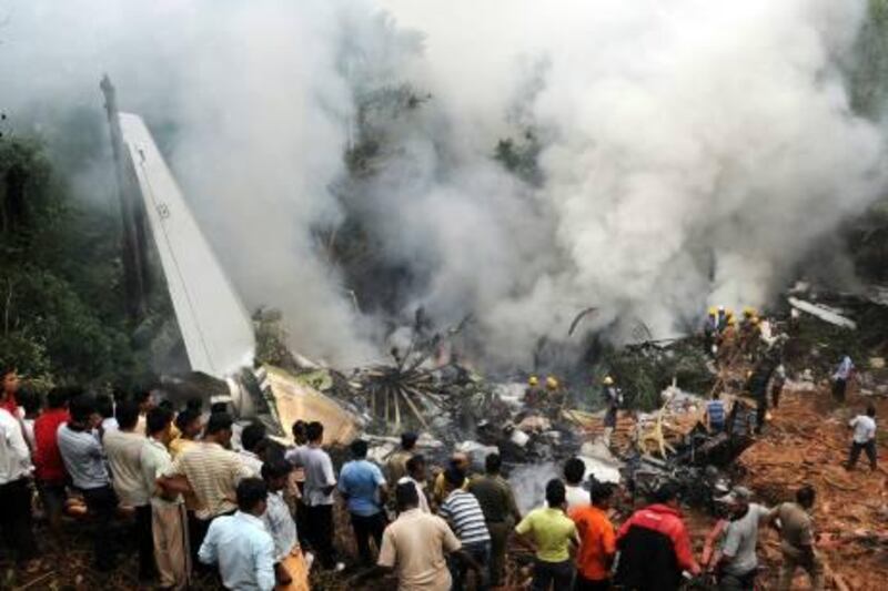 MANGALORE, INDIA - MAY 22: Smoke rises from the air plane crash site  on May 22, 2010 in Mangalore. An Air India Express Dubai-Mumbai Boeing 737-800 series aircraft overshot the runway on arrival and crashed into a forest. Airline officials say 8 people have been rescued while nearly 160 others are feared dead. (Photo by Solaris Images/Getty Images) *** Local Caption ***  GYI0060528712.jpg
