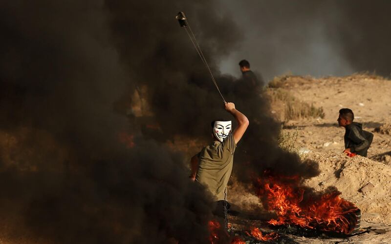 A Palestinian protester uses a slingshot to hurl stones during a demonstration on the beach near the maritime border with Israel, in Beit Lahia in the northern Gaza Strip. AFP