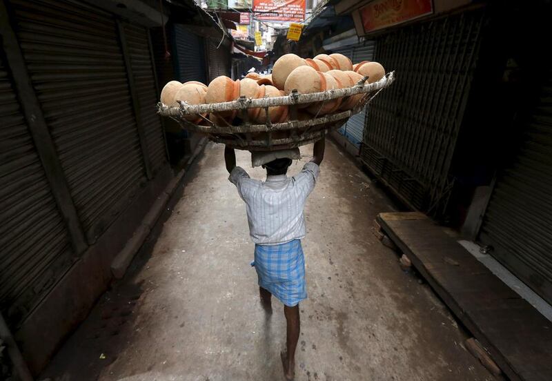 A man carries a basket filled with earthen pots for delivery to a sweet shop through an alley at a market place in Kolkata.  Rupak De Chowdhuri / Reuters