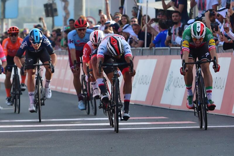Colombian rider of the UAE Team Emirates Fernando Gaviria (2nd R) crosses the finish line to win ahead of  Elia Viviani Italian rider for Deceuninck–Quick-Step during the second stage of the UAE cycling tour in Abu Dhabi on February 25, 2019.  / AFP / GIUSEPPE CACACE
