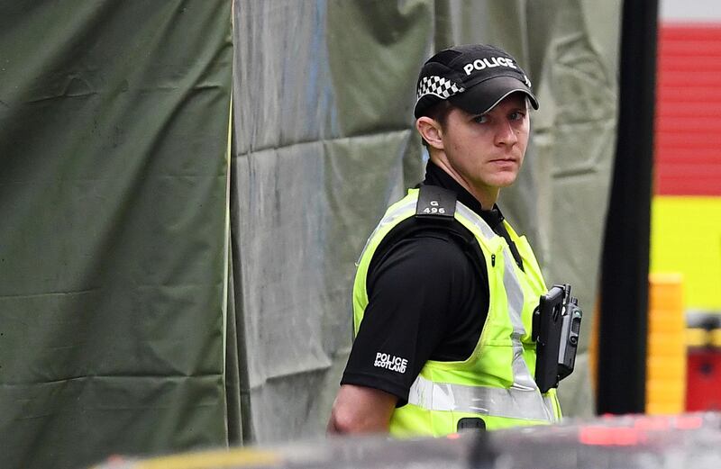 A police officer stands in front of a cordoned off area. Getty