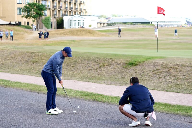 Rory McIlroy putts off a road next to the 17th green. PA