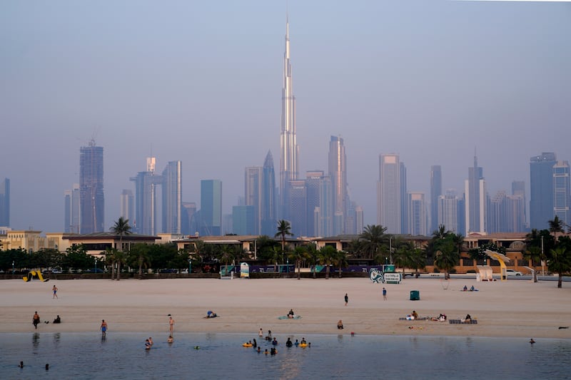 People cool off by swimming on Dubai's coast. AP  