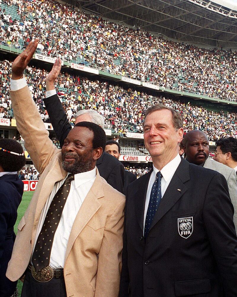 Zulu King Goodwill Zwelithini (L) waves to some 60,000 soccer supporters together with chairman of the FIFA technical team, Alan Rothenberg (R), during a local match 12 March 2000as part of their inspection tour to South Africa's World Cup bid at Durban's Kings Park stadium. (Photo by RAJESH JANTILAL / AFP)