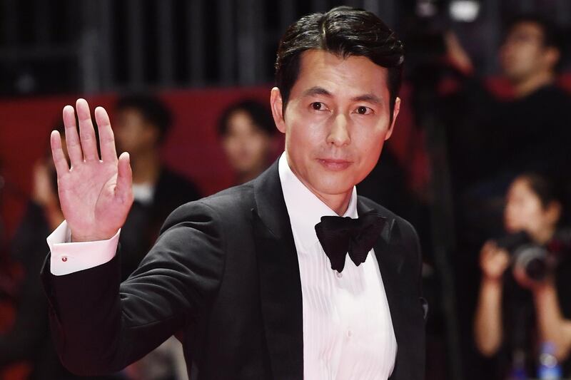 South Korean actor Jung Woo-sung waves to fans as he arrives for the opening ceremony of the 24th Busan International Film Festival.  EPA