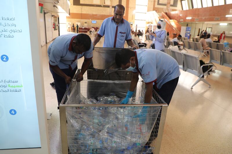 Workers collect plastic bottles for recycling. Nilanjana Gupta / The National