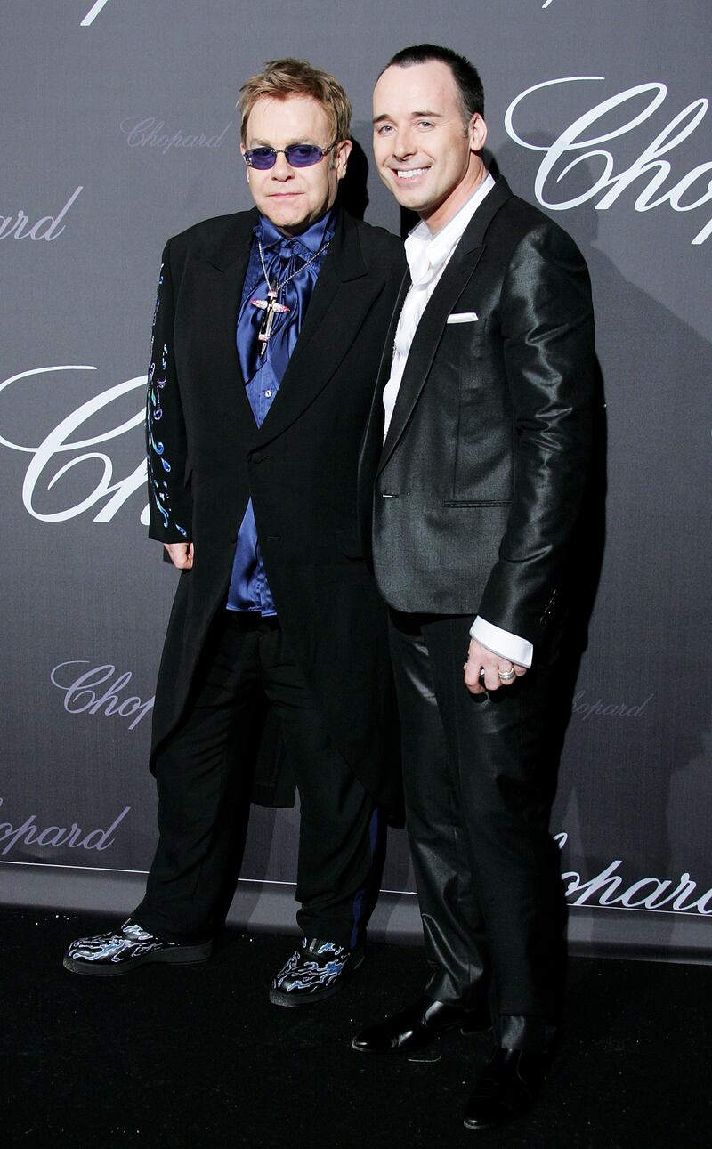 Elton John, in a black jacket with a blue splash pattern and shirt, and David Furnish arrive at a Chopard event during the 60th International Cannes Film Festival on May 25, 2007. Getty Images