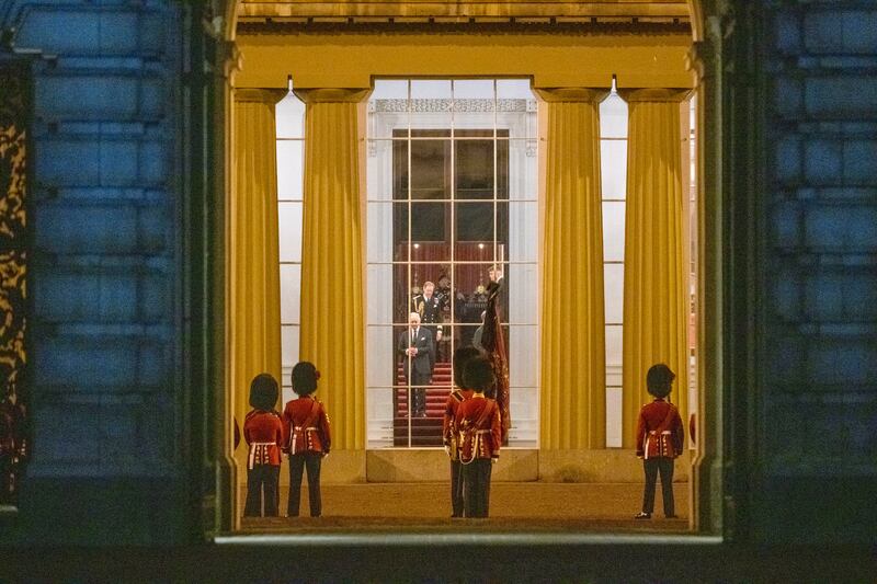 King Charles III watches from a window as the hearse carrying the coffin of Queen Elizabeth arrives at Buckingham Palace. AP
