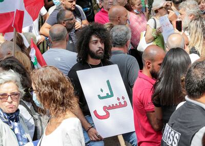 Activists and relatives of victims of the Beirut port explosion lift placards as they demonstrate on September 29, 2021 outside the Lebanese capital's Justice Palace,to protest the suspension of the investigation into the August 4, 2020 port explosion. AFP