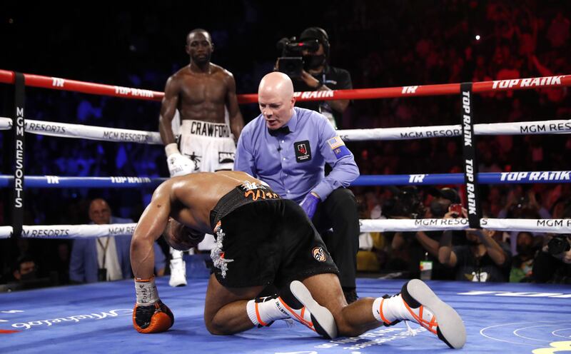 Referee Celestino Ruiz checks on Shawn Porter after he was knocked down by WBO champion Terence Crawford in the 10th round. AFP