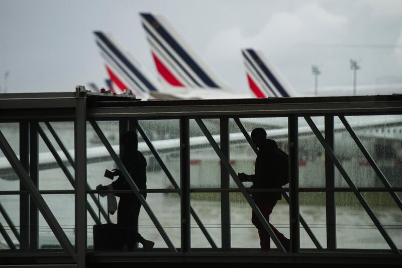 Passengers board a flight at Charles de Gaulle airport in Roissy, France. Bloomberg
