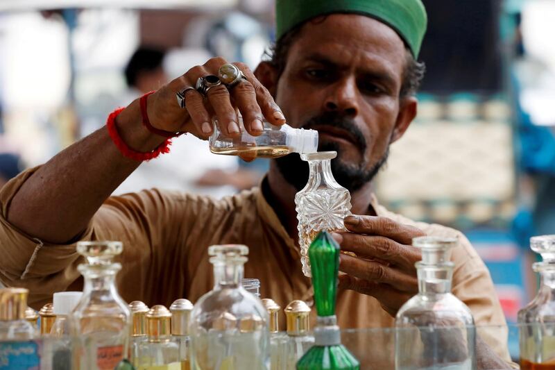 A man fills a bottle with oil perfume along a wholesale market as the spread of the coronavirus disease (COVID-19) continues, in Karachi, Pakistan. REUTERS