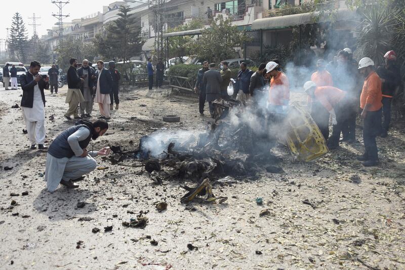 Pakistani police collect evidence at the site of a car bombing in Islamabad on December 23. Reuters