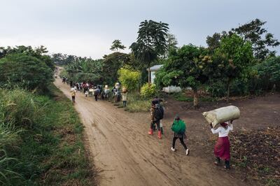 Displaced people carrying their belongings flee the scene of an attack allegedly perpetrated by the rebel group Allied Democratic Forces (ADF) in the Halungupa village near Beni on February 18, 2020. (Photo by Alexis Huguet / AFP)