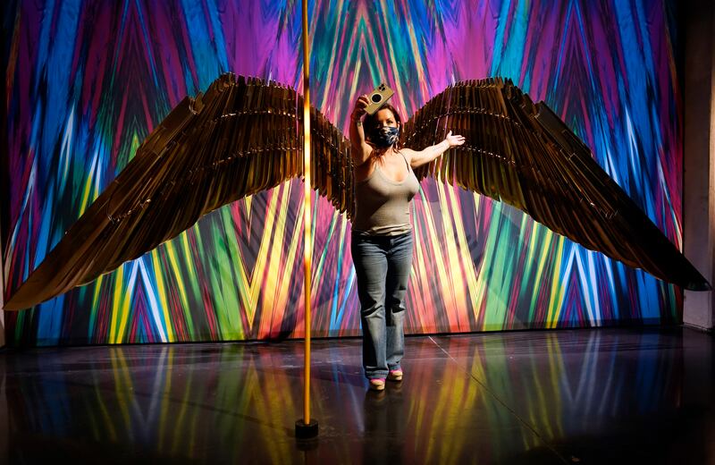 Dawn Garcia takes a selfie in front of Golden Armor Wings featured in the film "Wonder Woman 1984" in the "Action and Magic Made Here" interactive experience at the Warner Bros.  Studio Tour Hollywood media preview on June 24, 2021, in Burbank, Calif.  (AP Photo / Chris Pizzello)