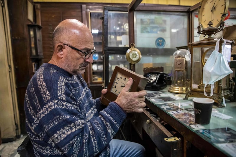 Ashod Papazian, a 64-year-old Armenian-Egyptian watchmaker, examines a clock in his family-owned business: the Francis Papazian watchmaker's shop in Cairo. AFP