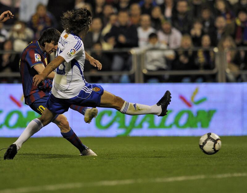 Barcelona's Argentinian forward Lionel Messi (L) kicks to score the second goal against Zaragoza during their Spanish League football match between Zaragoza and Barcelona on March 21, 2010 at La Romareda stadium in Zaragoza.   AFP PHOTO/ LLUIS GENE (Photo by LLUIS GENE / AFP)